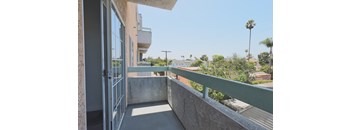A balcony with a metal railing and a concrete floor.