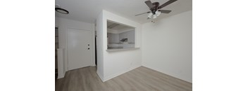 A room with a ceiling fan and a door leading to another room.