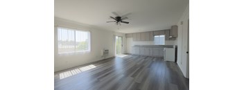 A room with a ceiling fan and wooden flooring.