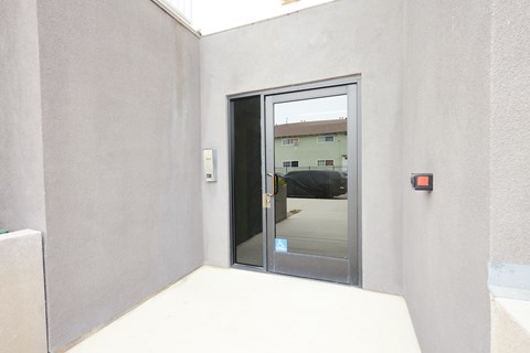 A glass door with a handle is in the middle of a white wall.