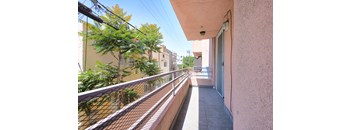 A balcony with a metal railing and a tiled floor.