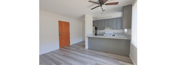 A room with a ceiling fan and a wooden door.