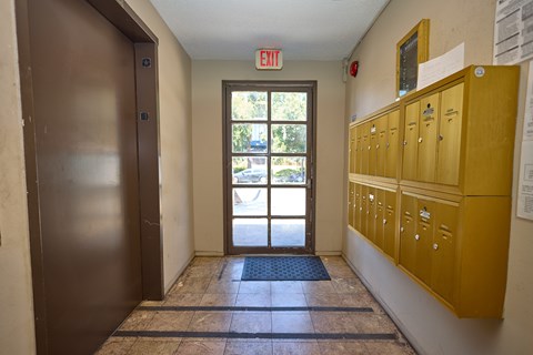A hallway with a brown door and yellow lockers.