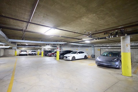 A parking garage with several cars parked in it.