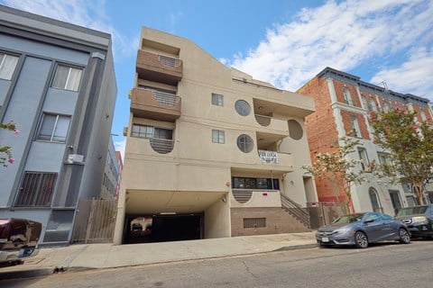 A modern building with a unique design is situated on a street corner.