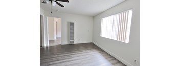 A room with a ceiling fan and a window with blinds.
