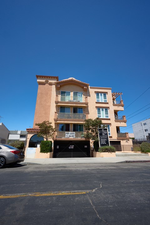 A tan building with a balcony on the second floor.