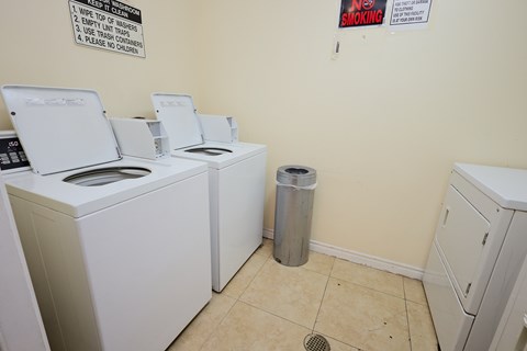 A laundromat with washers and dryers and a sign that says No Smoking.