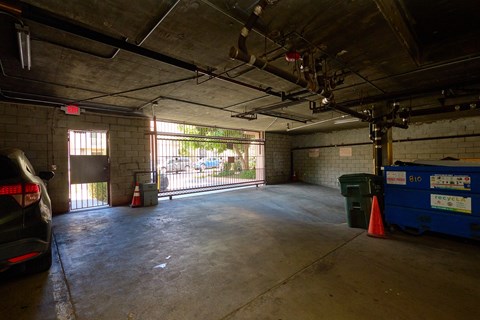 A large empty garage with a car parked on the left side.