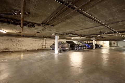A parking garage with a few cars parked.