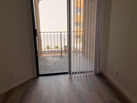 a living room with a sliding glass door to a balcony
