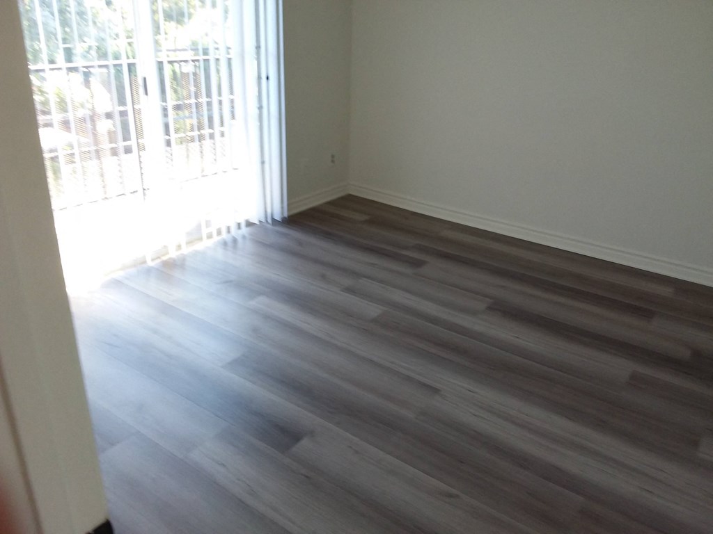 the living room has hardwood flooring and a window