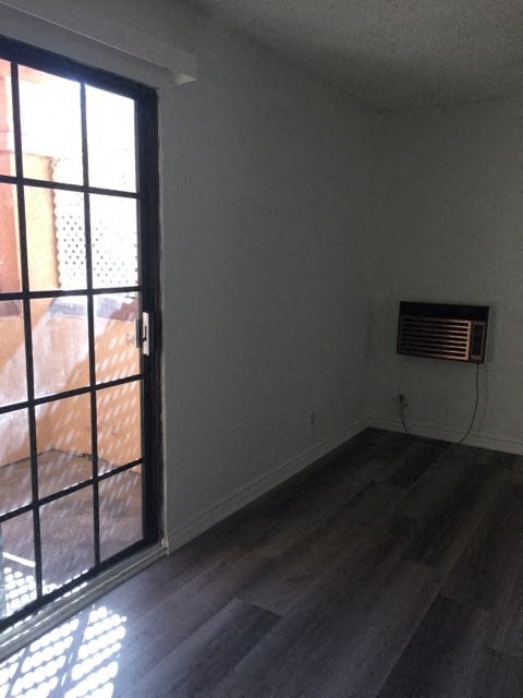 an empty room with an open door and a window