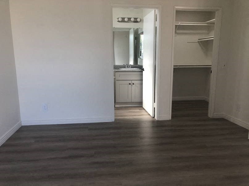 a living room with a hard wood floor and a kitchen
