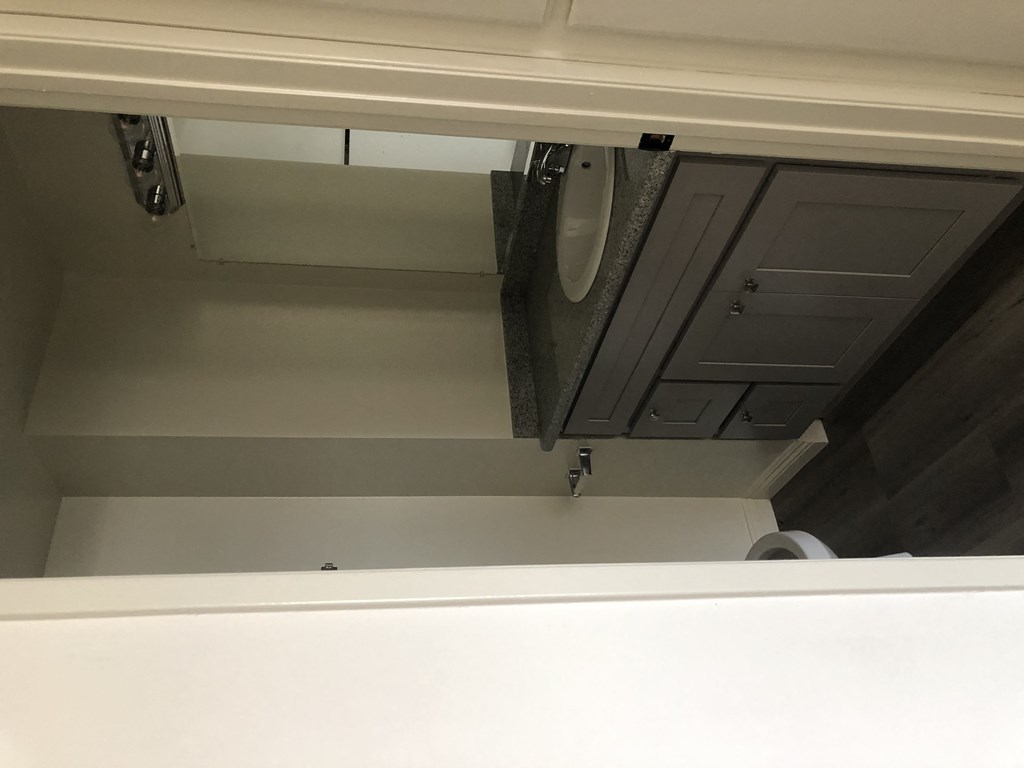 the underside of a bathroom vanity with a sink and a mirror