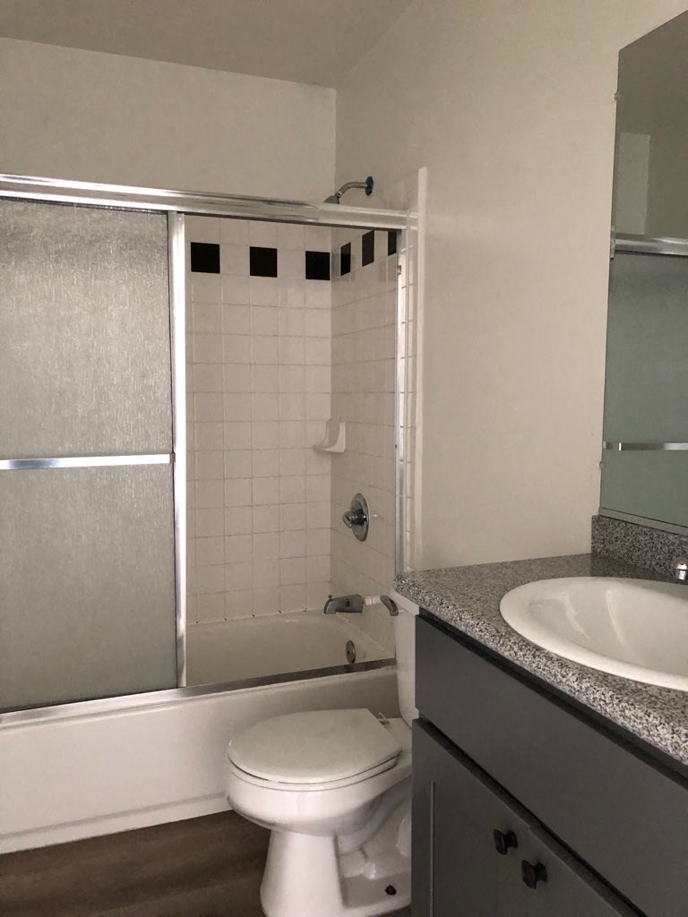 a bathroom with a toilet and a sink and a shower