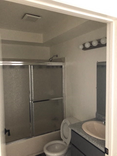 a bathroom with a shower and a sink and a toilet