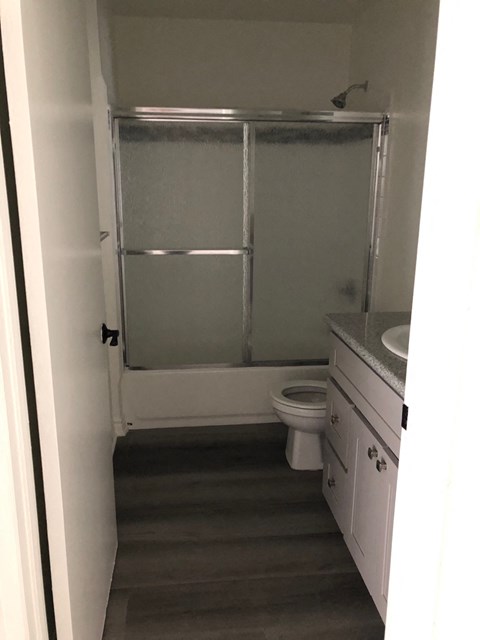 a bathroom with a shower and a sink and a toilet