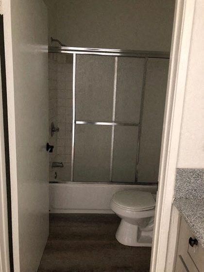 a bathroom with a white toilet and a shower