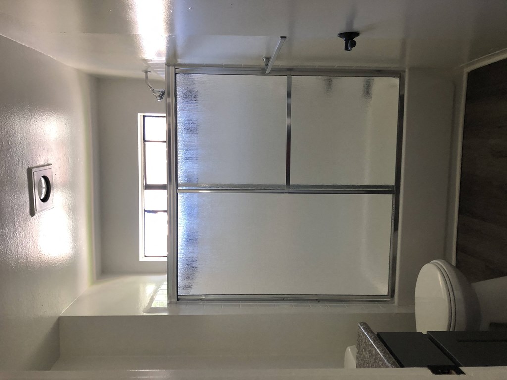 a shower with a glass door in a bathroom