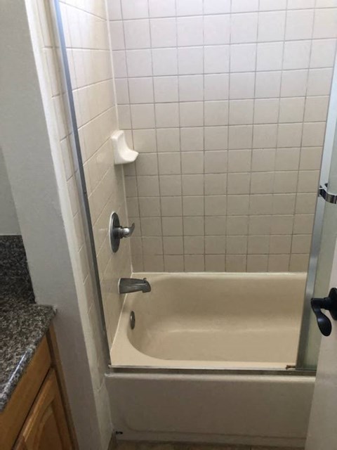 a white bathroom with a shower and a tub