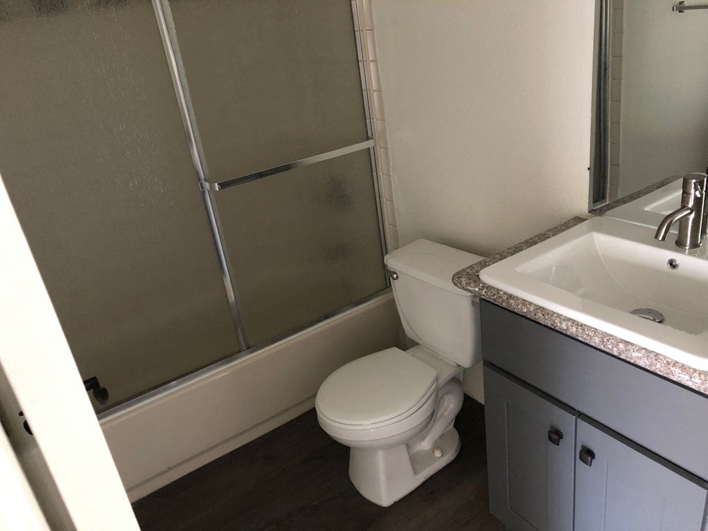 a bathroom with a toilet and a sink and a shower