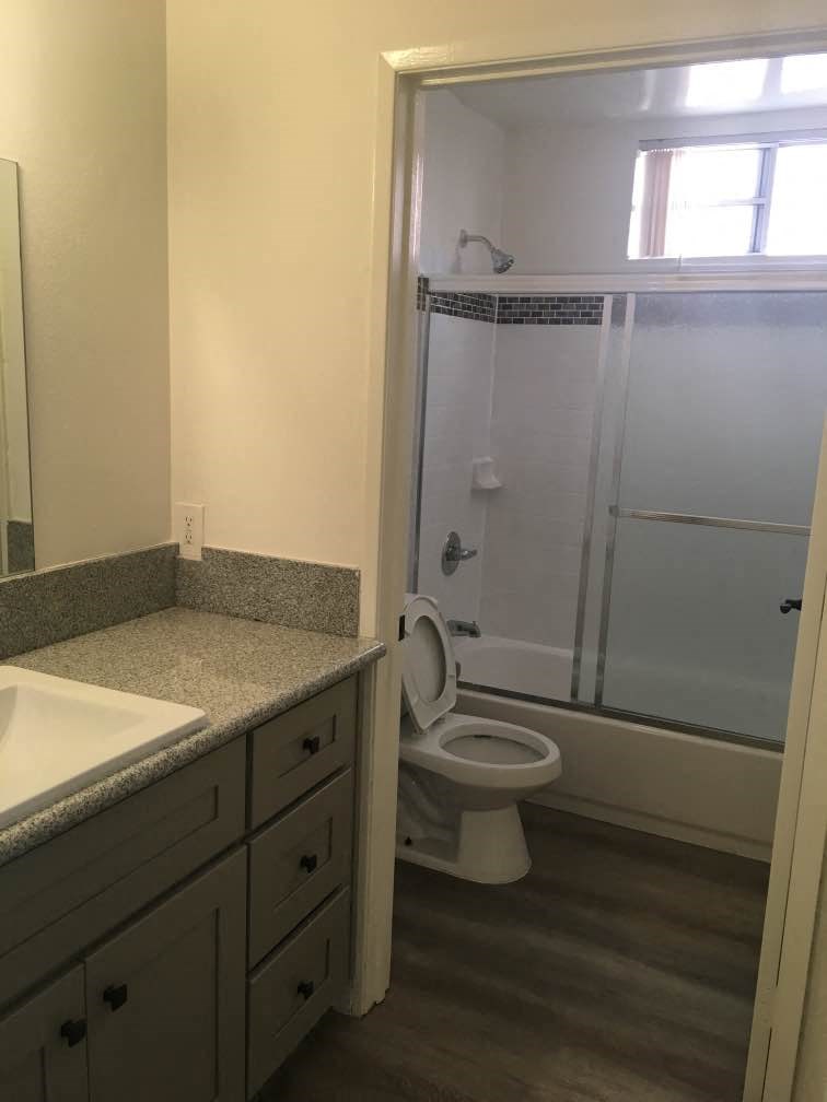 a bathroom with a toilet and a shower and a sink