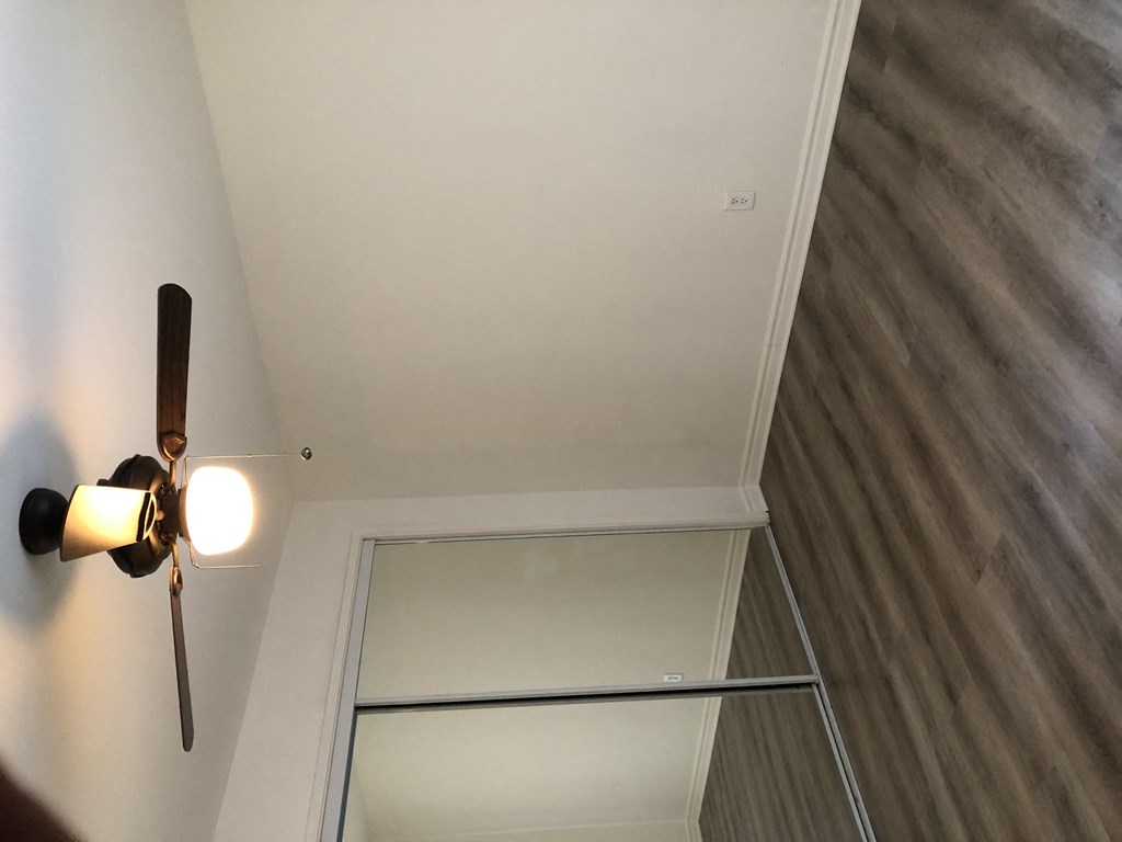 a room with a ceiling fan and a mirrored closet