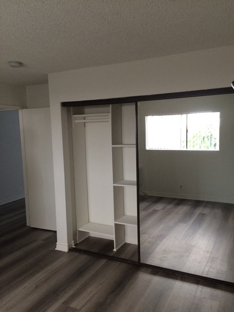 an empty living room with a closet and a window