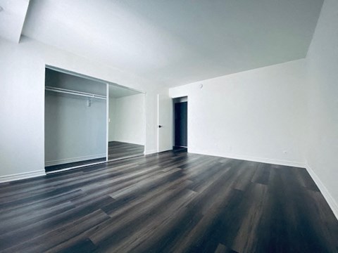 an empty living room with white walls and wooden floors