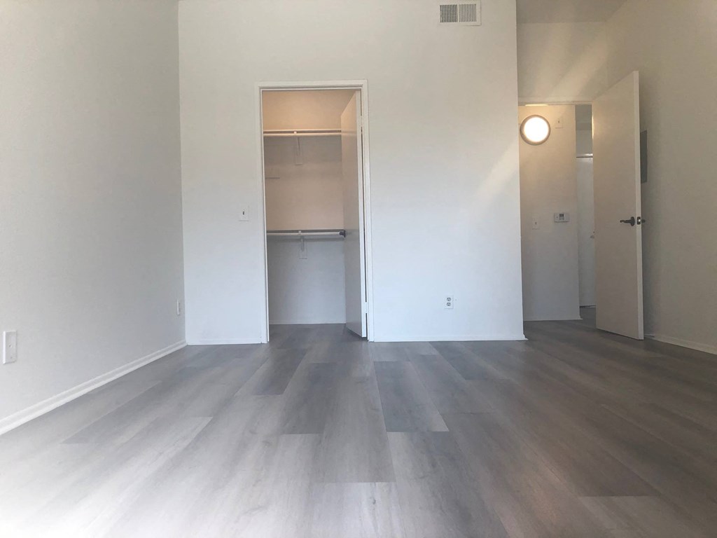 an empty living room with white walls and wood flooring