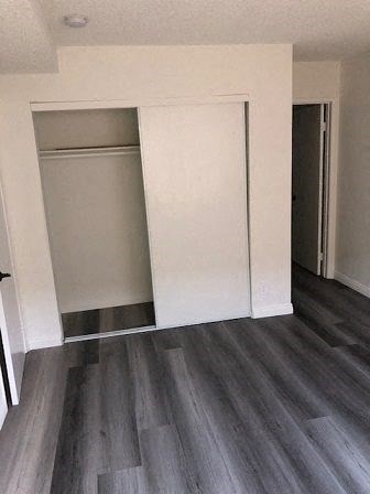 an empty living room with white walls and wood floors