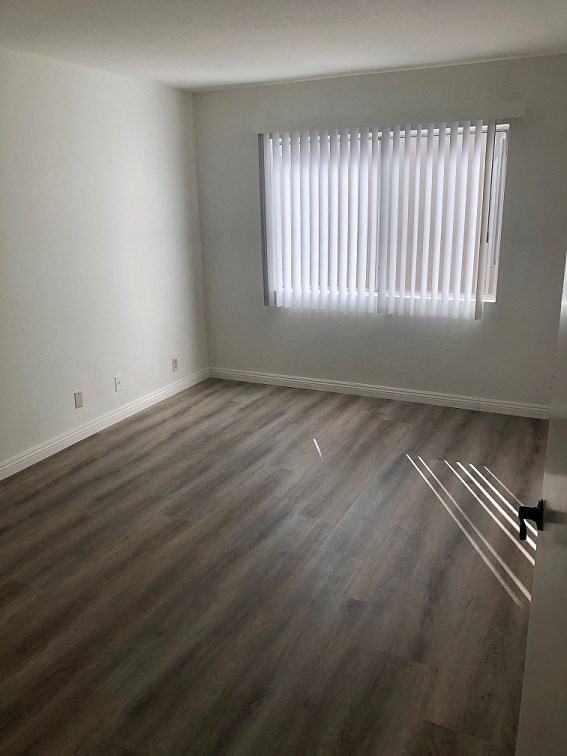 an empty room with wooden floors and a window