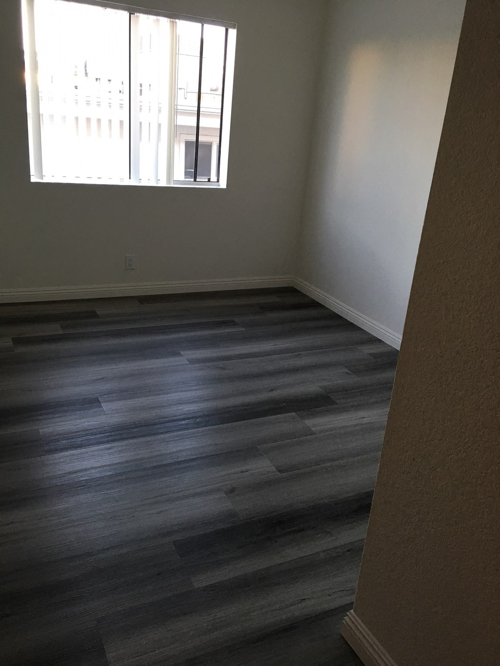 an empty room with wooden floors and a window