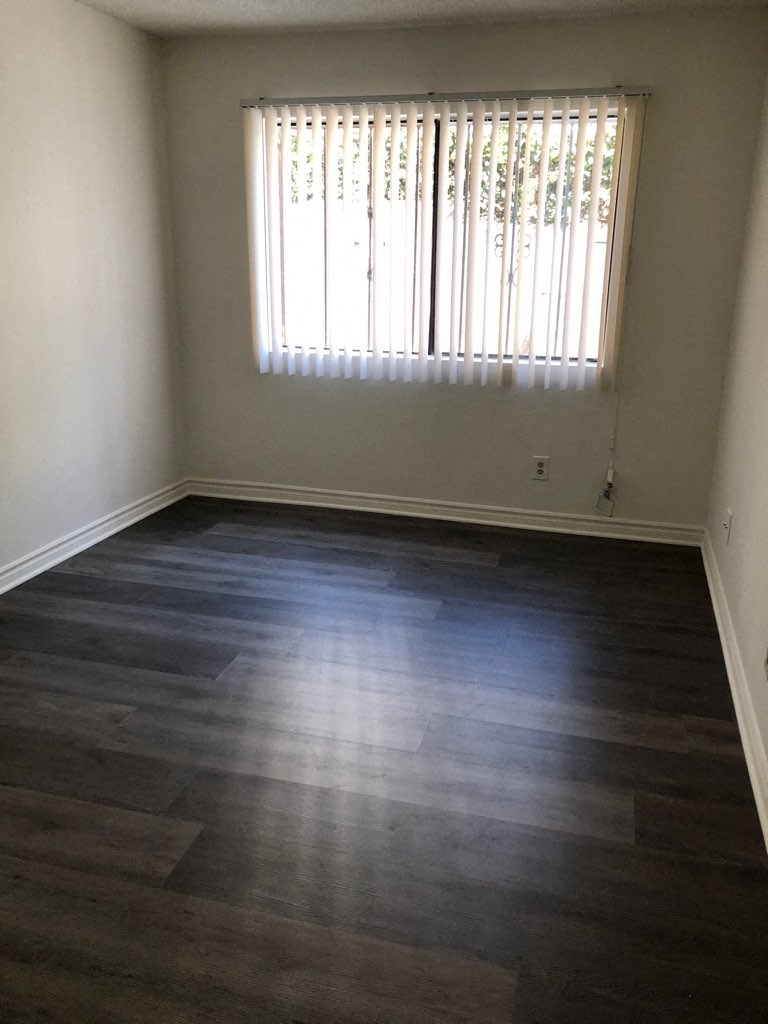 a empty room with wood floors and a window