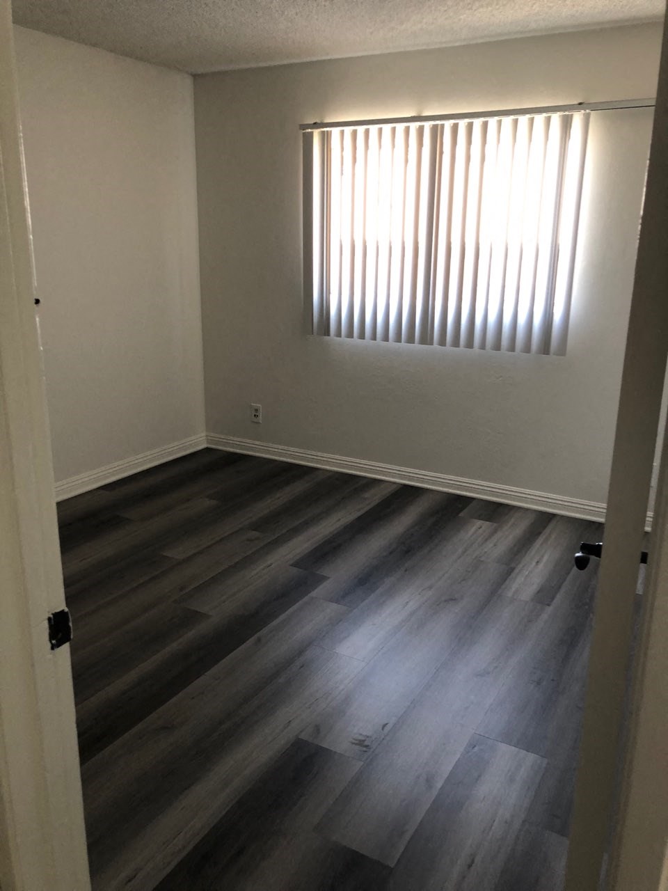 an empty room with wooden floors and a window