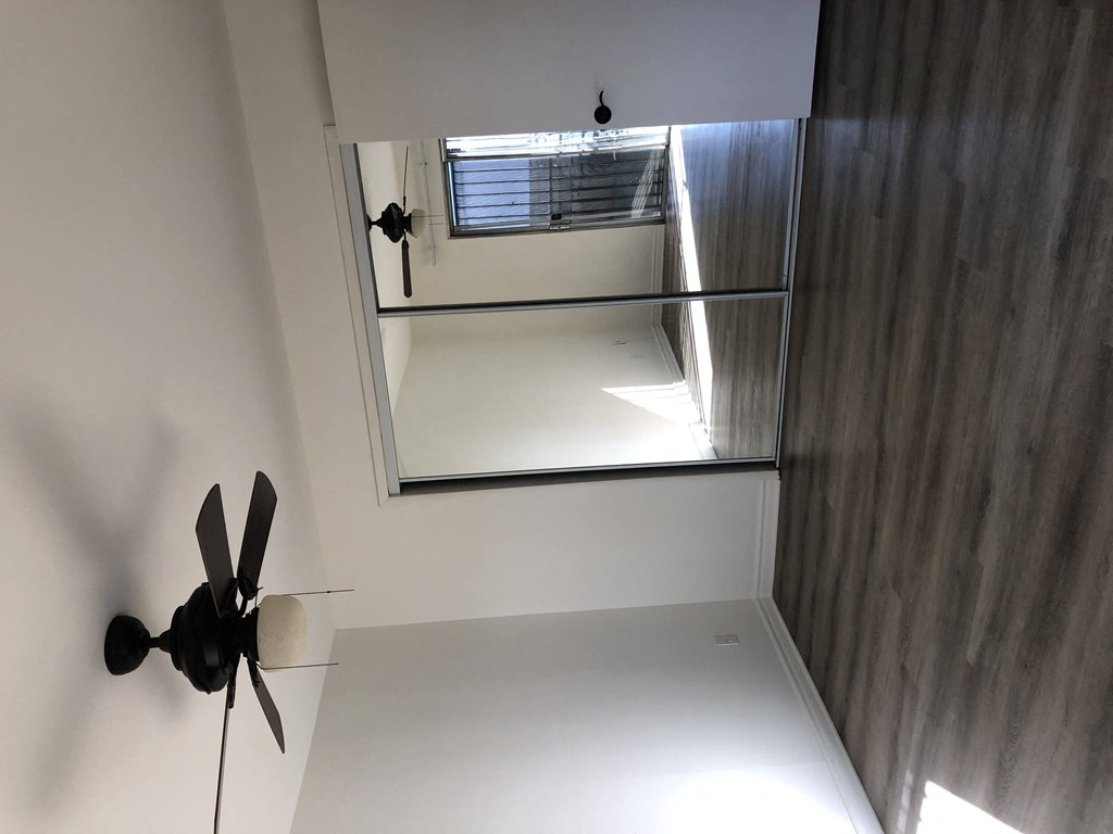 a room with a window and a ceiling fan