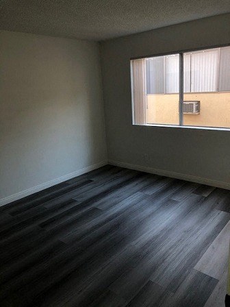 an empty room with wooden floors and a window