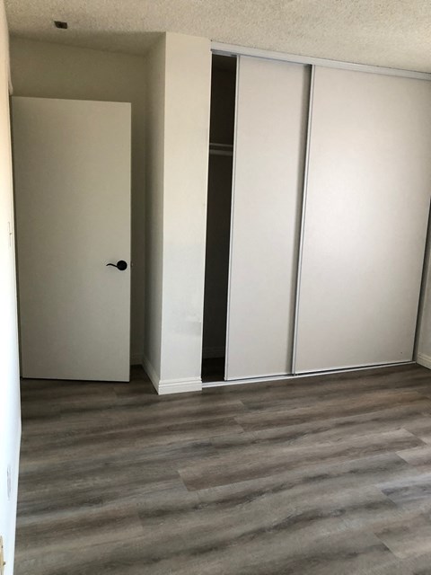 a living room with white walls and a wood floor