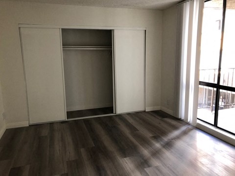 an empty living room with wood floors and a closet