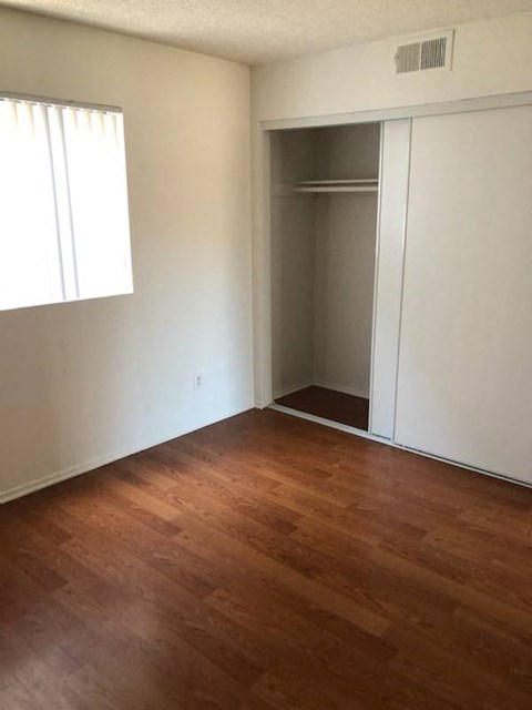 an empty room with a wooden floor and a closet