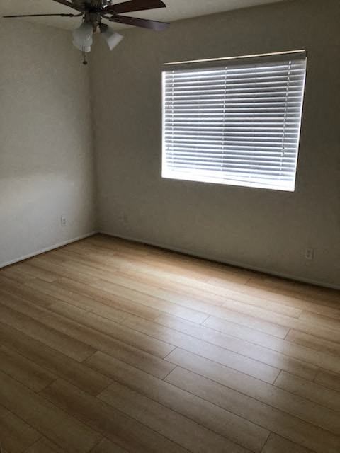 an empty room with a window and wooden floors