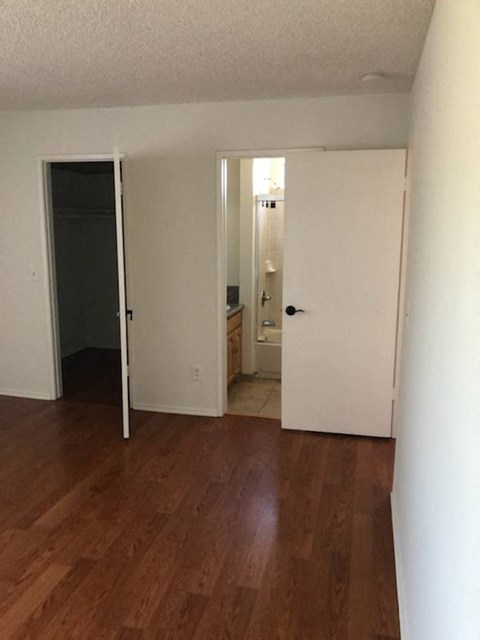 a living room with a wooden floor and a white door