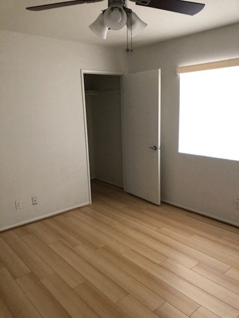 an empty living room with wooden floors and a door