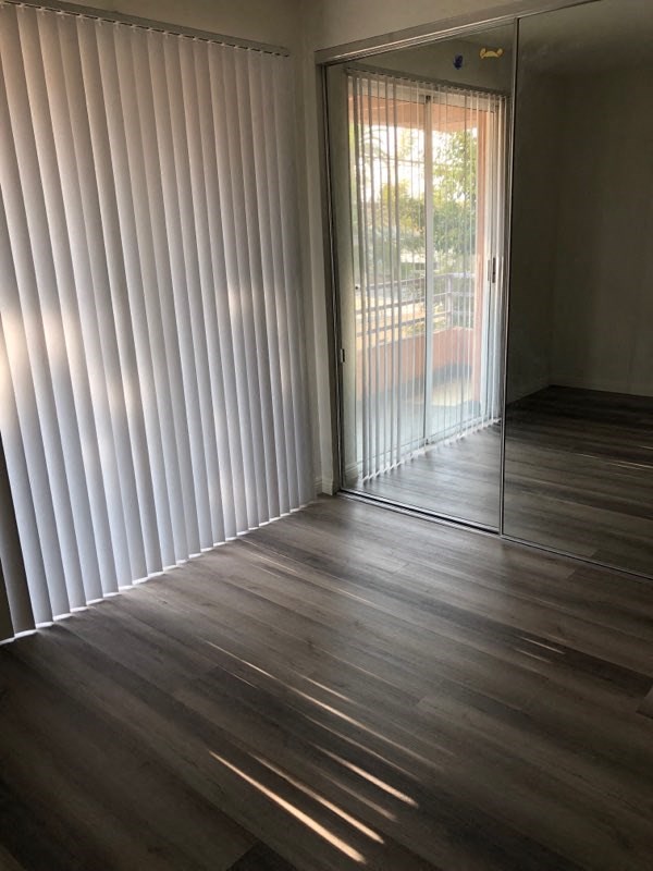 a living room with a wooden floor and a sliding glass door