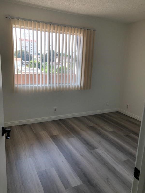 an empty room with wooden floors and a window