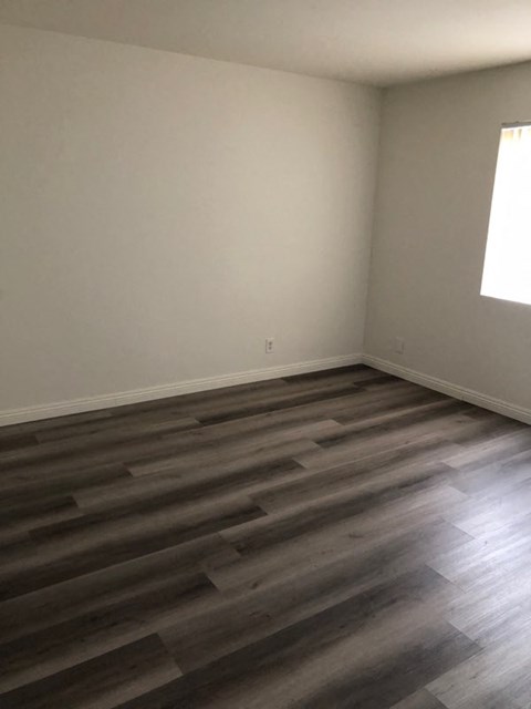 a empty room with wooden floors and a window