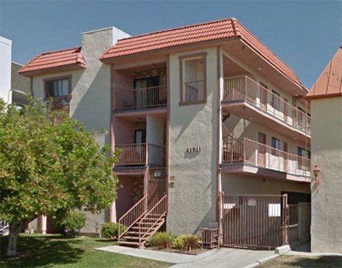 an apartment building with stairs and a tree