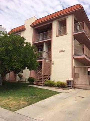 an apartment building with a tree in front of it