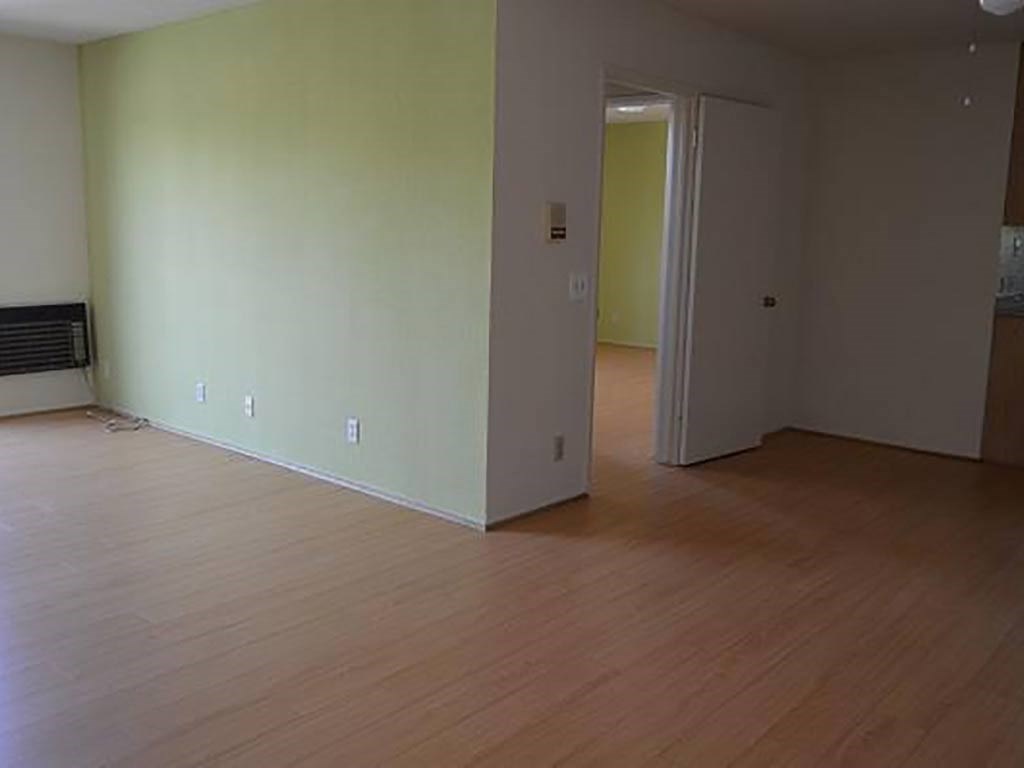 an empty living room with a wooden floor